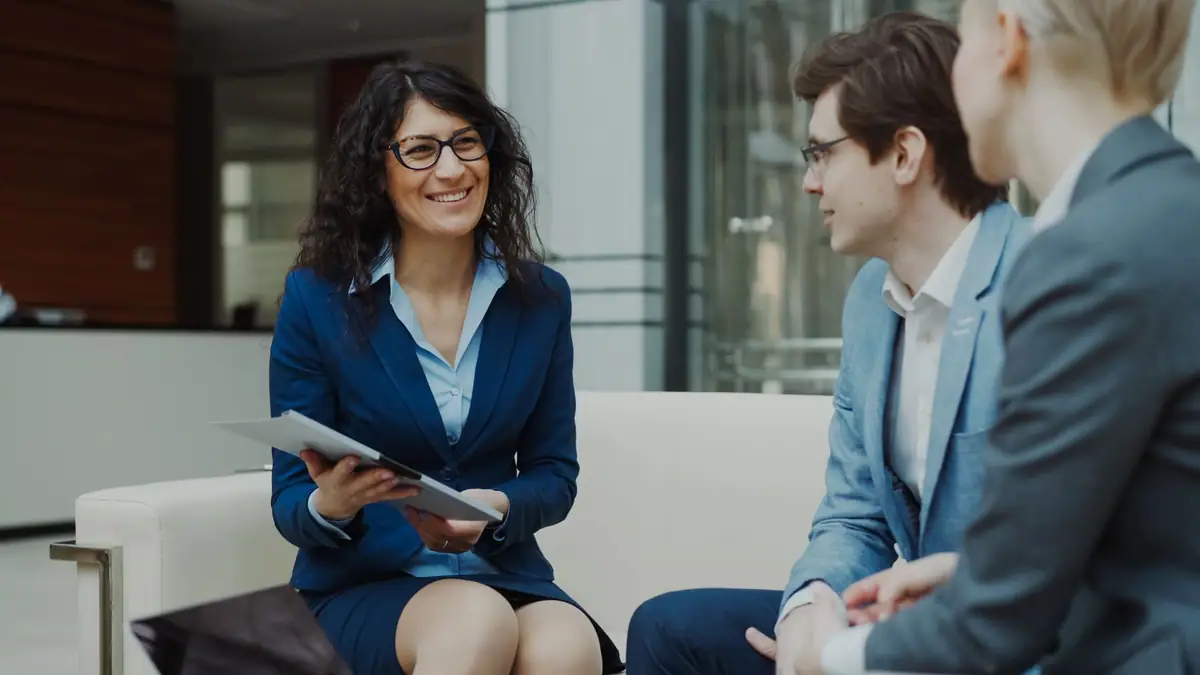 Two professionals in conversation in a bright office lounge