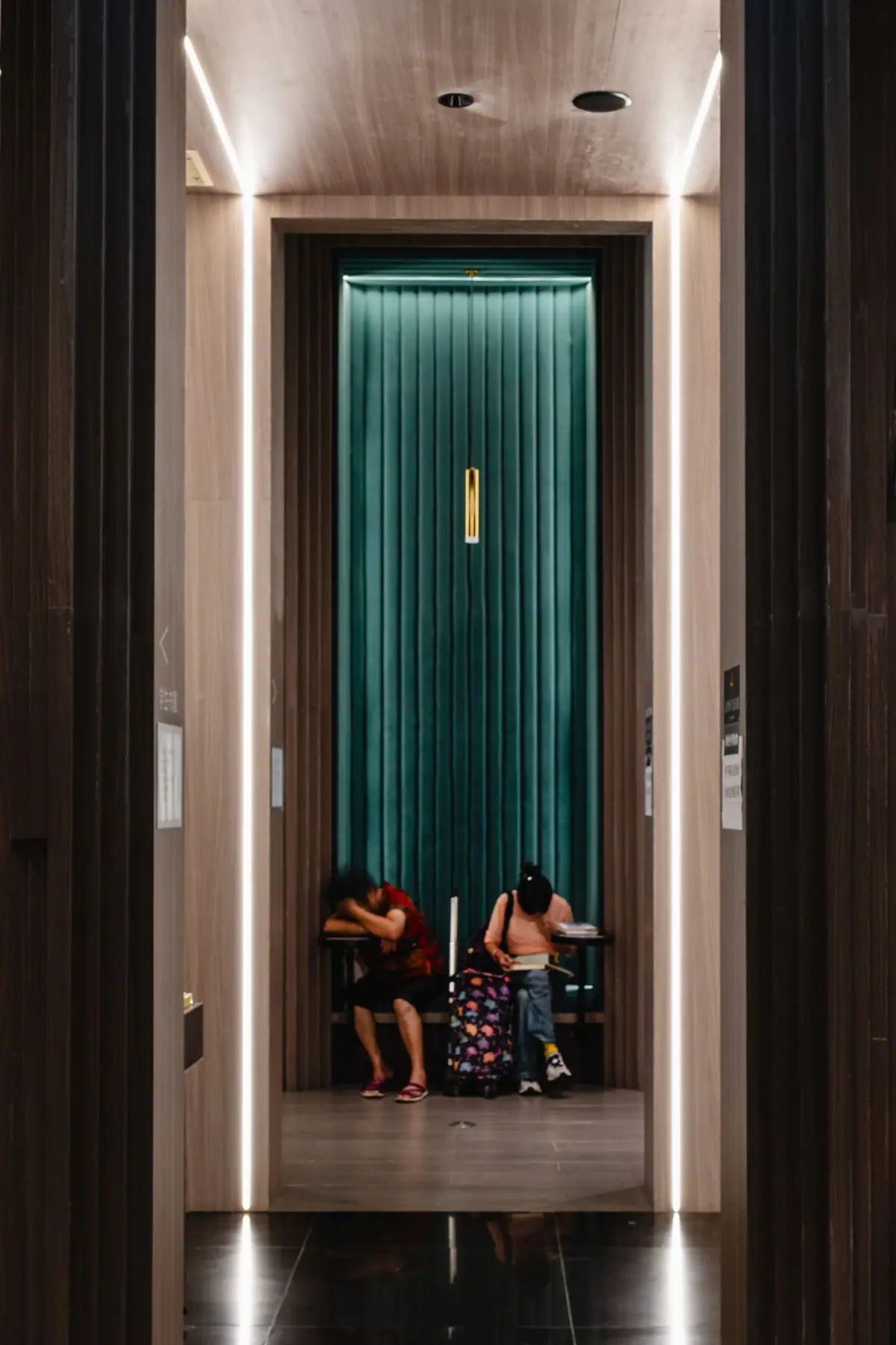 Hotel lobby with dark wood panelling and an elevator entrance