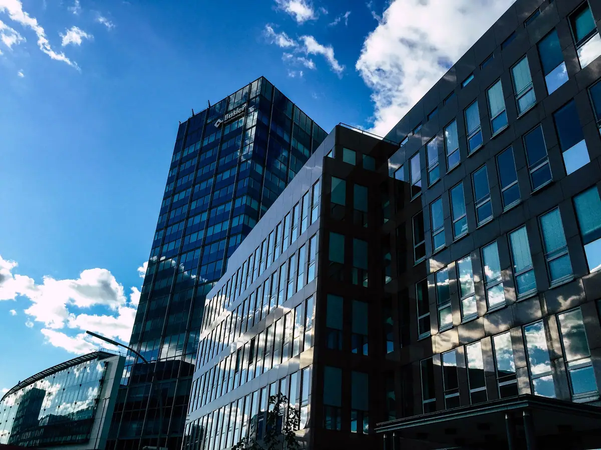 Modern glass office buildings reflecting a blue sky