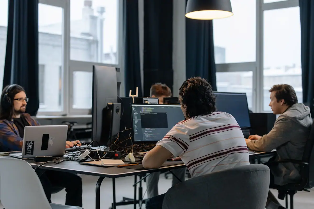 Team working at computers with large monitors in a modern technology office