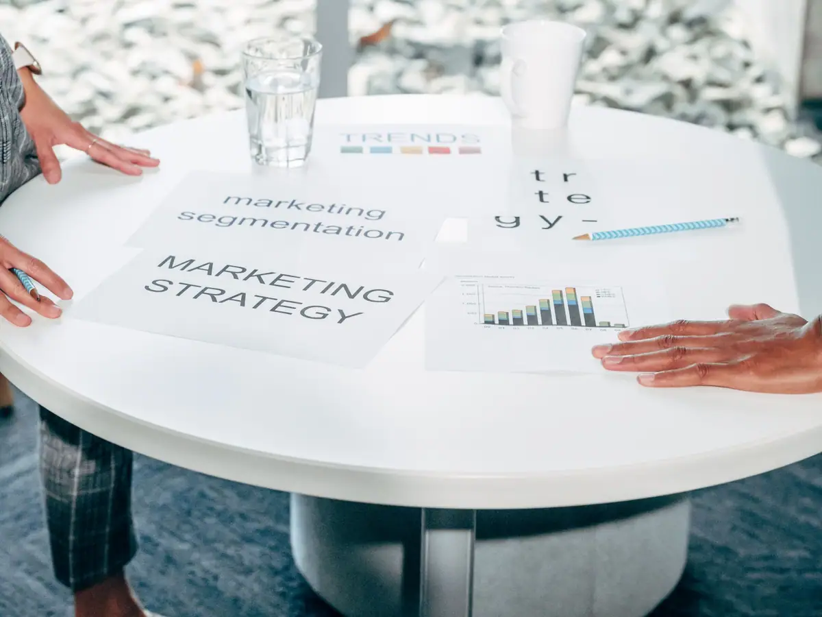 Printed strategy documents spread across a round meeting table
