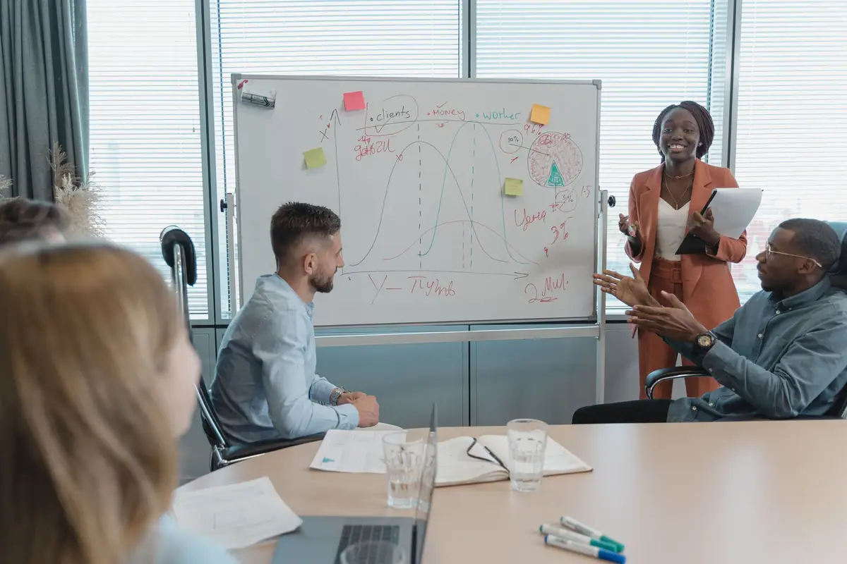 Team reviewing a strategy diagram on a whiteboard in a bright meeting room
